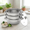 3-tier stainless steel steamer pan set with glass lid in a kitchen with vegetables