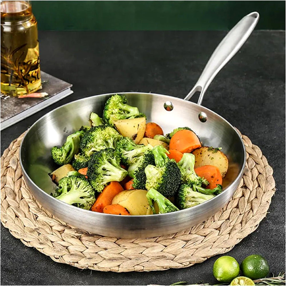 Uncoated stainless steel frying pan with roasted vegetables on a woven placemat