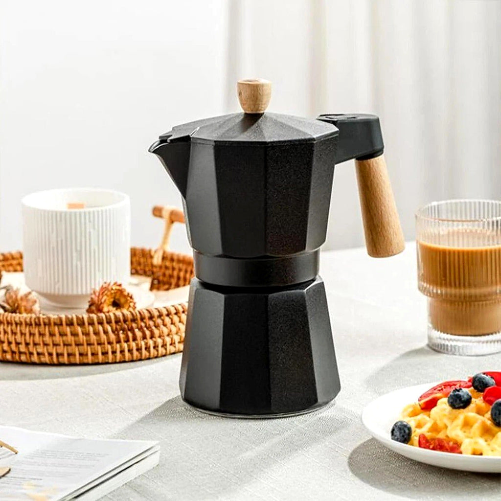 Black stovetop moka pot with coffee cups