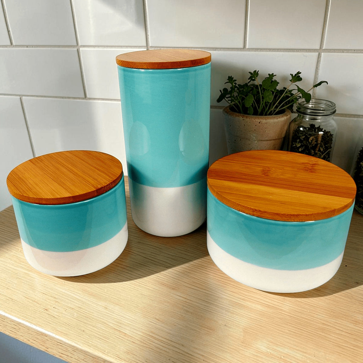 Aqua green ceramic canisters with bamboo lids on the worktop