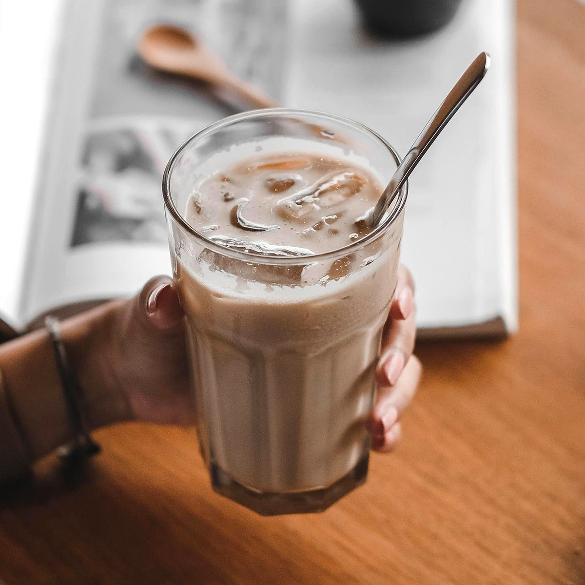 Stirring an iced latte with a long-handled spoon