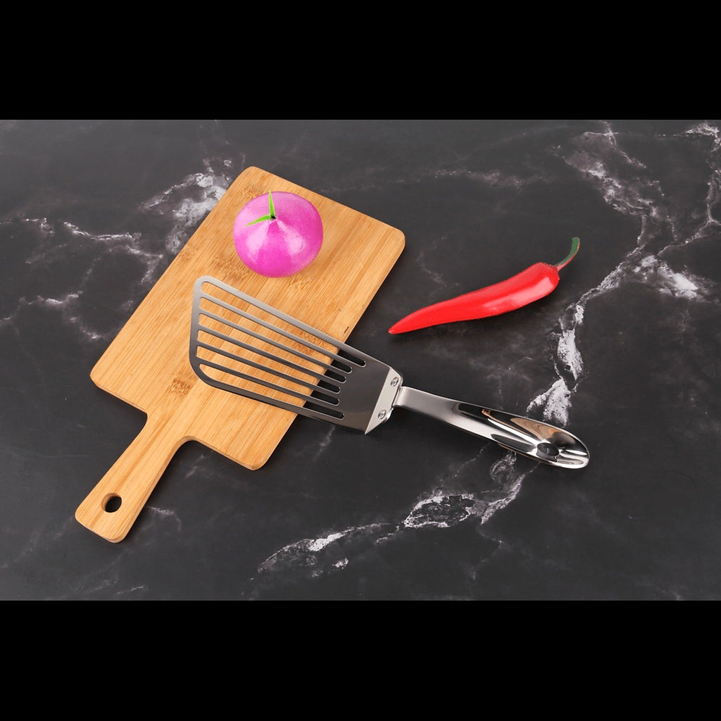 Stainless steel slotted turner on a chopping board