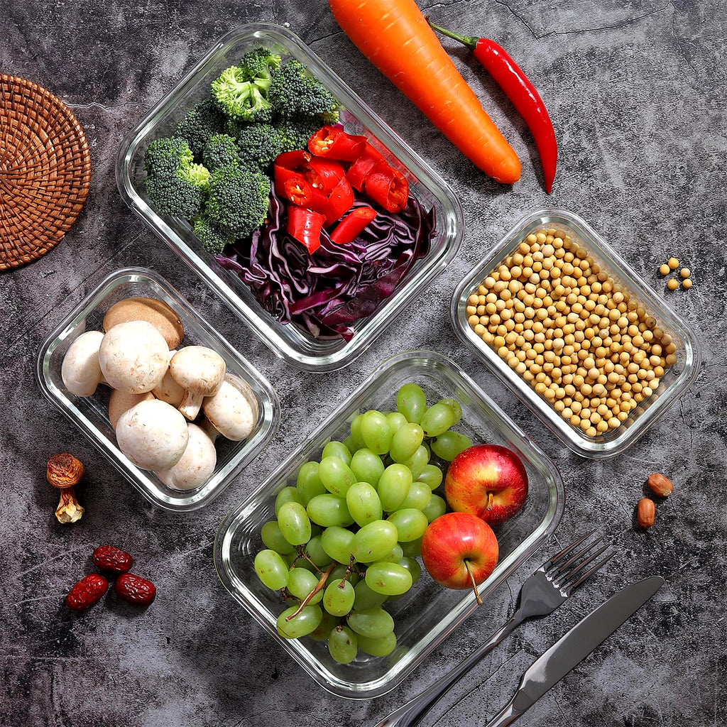 Glass food storage containers filled with fresh vegetables and fruit