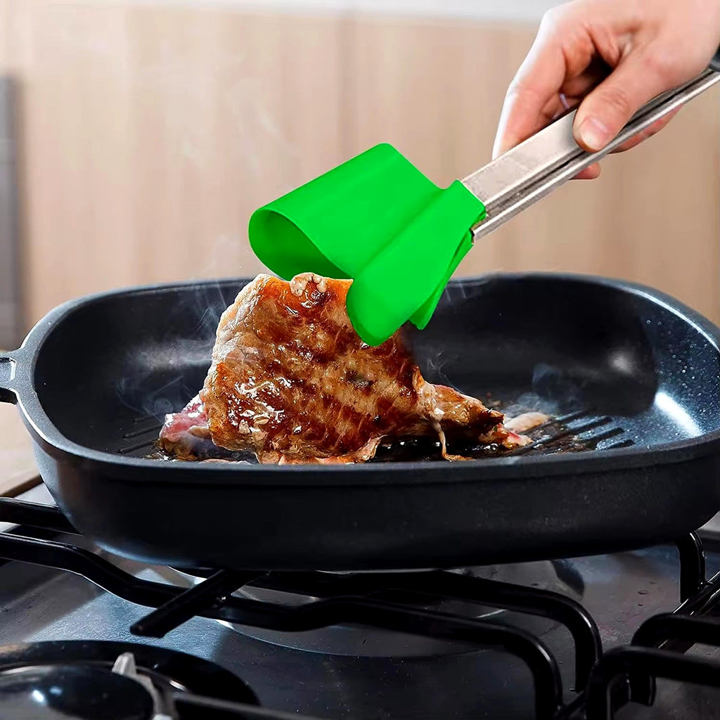 Spatula tongs turning steak in a griddle pan