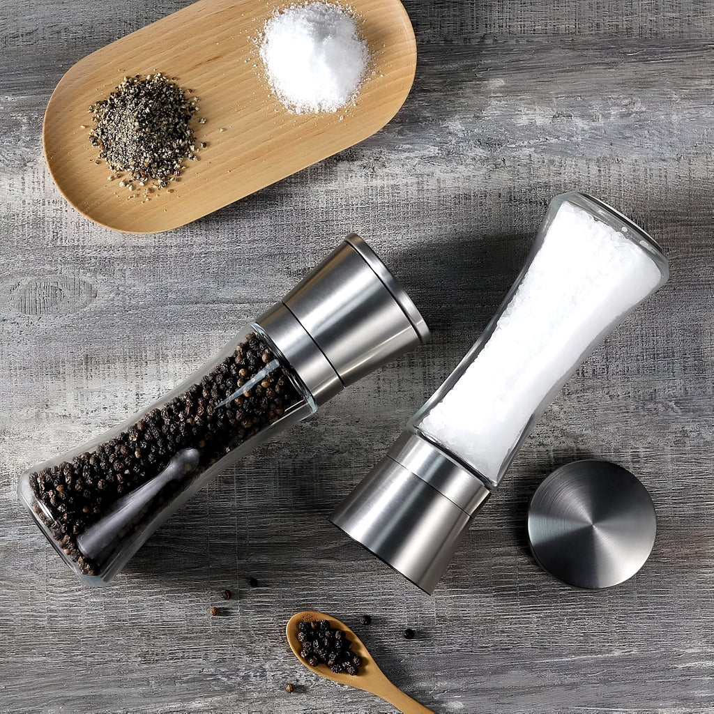 Stainless steel salt and pepper grinders on a table