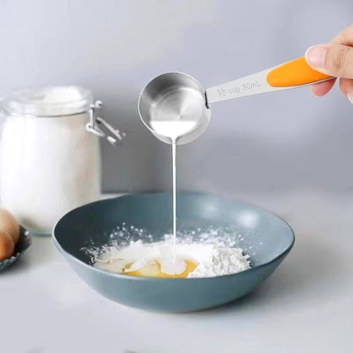 Scooping flour with a stainless steel measuring cup