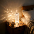 Faceted table lamp glowing on a bedside table