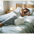 Contour memory foam knee pillow in use between the knees of a side sleeper